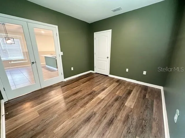 a view of a room with wooden floor and windows