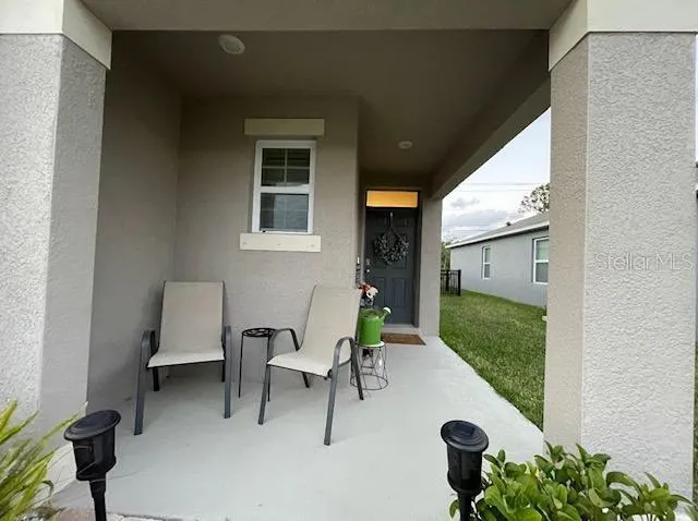 a view of a porch with furniture and garden