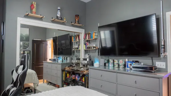 a bedroom with a bed a mirror and wooden floor