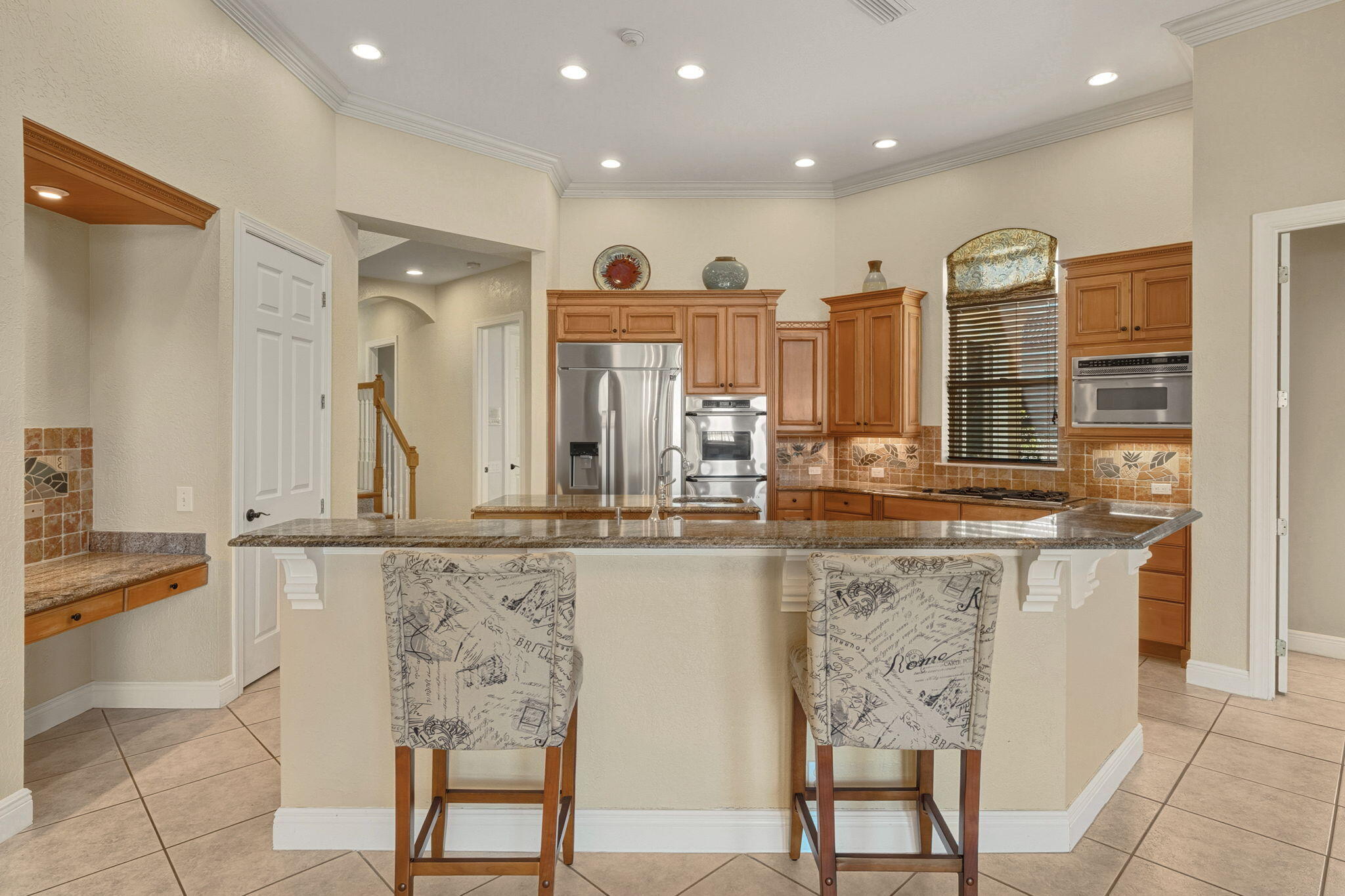4327 Stonebridge Road Destin, FL 32541 - Photo 13 of 51 a view of a kitchen with kitchen island granite countertop wooden cabinets and stainless steel appliances