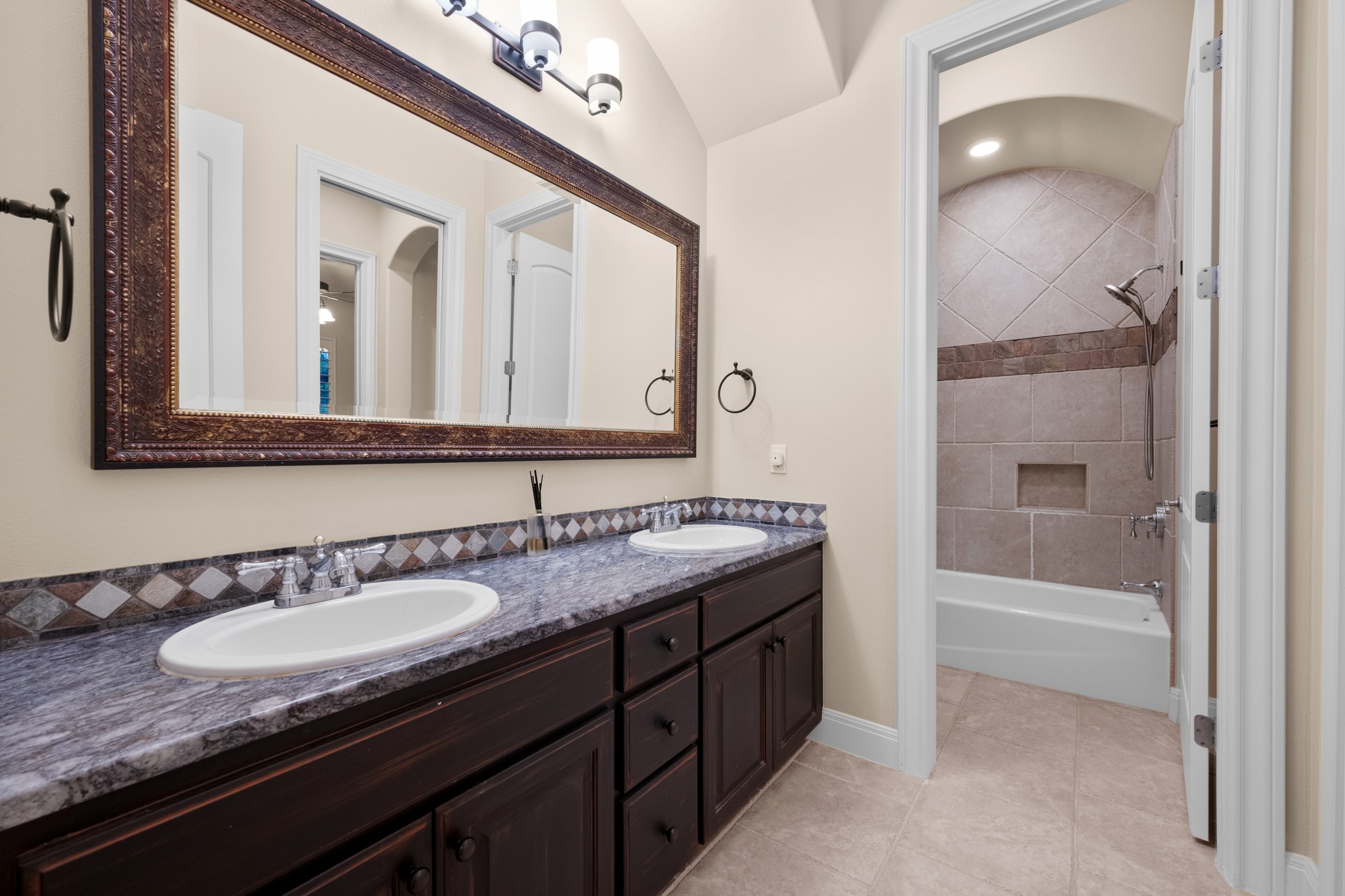 1012 Sailmaster Street Lakeway, TX 78734 - Photo 17 of 26 a bathroom with a granite countertop sink a mirror and a bathtub