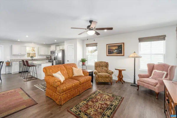 a living room with furniture kitchen view and a window