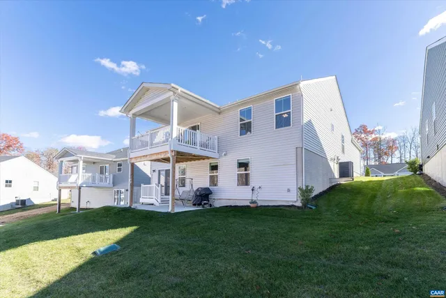 a view of a house with a big yard and large trees