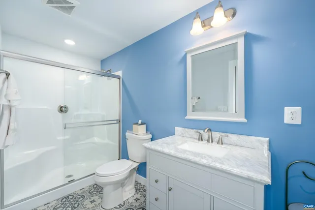 a bathroom with a granite countertop sink toilet and shower