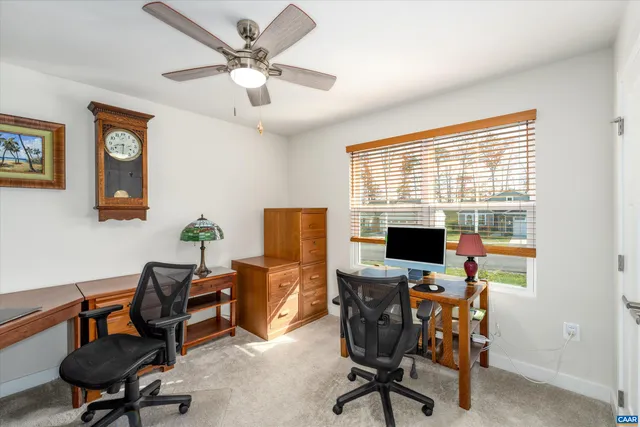 a view of a workspace with furniture and a window