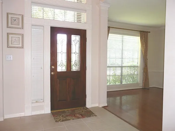 a view of a hallway with wooden floor and windows