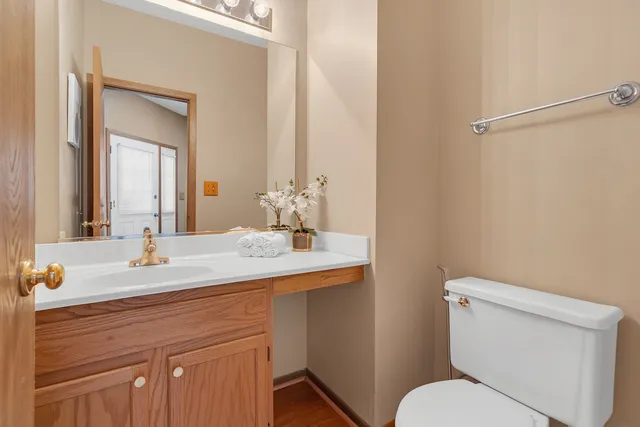 a bathroom with a granite countertop sink mirror and a toilet