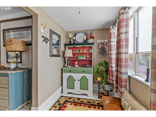 a picture of a living room with a rug and a window