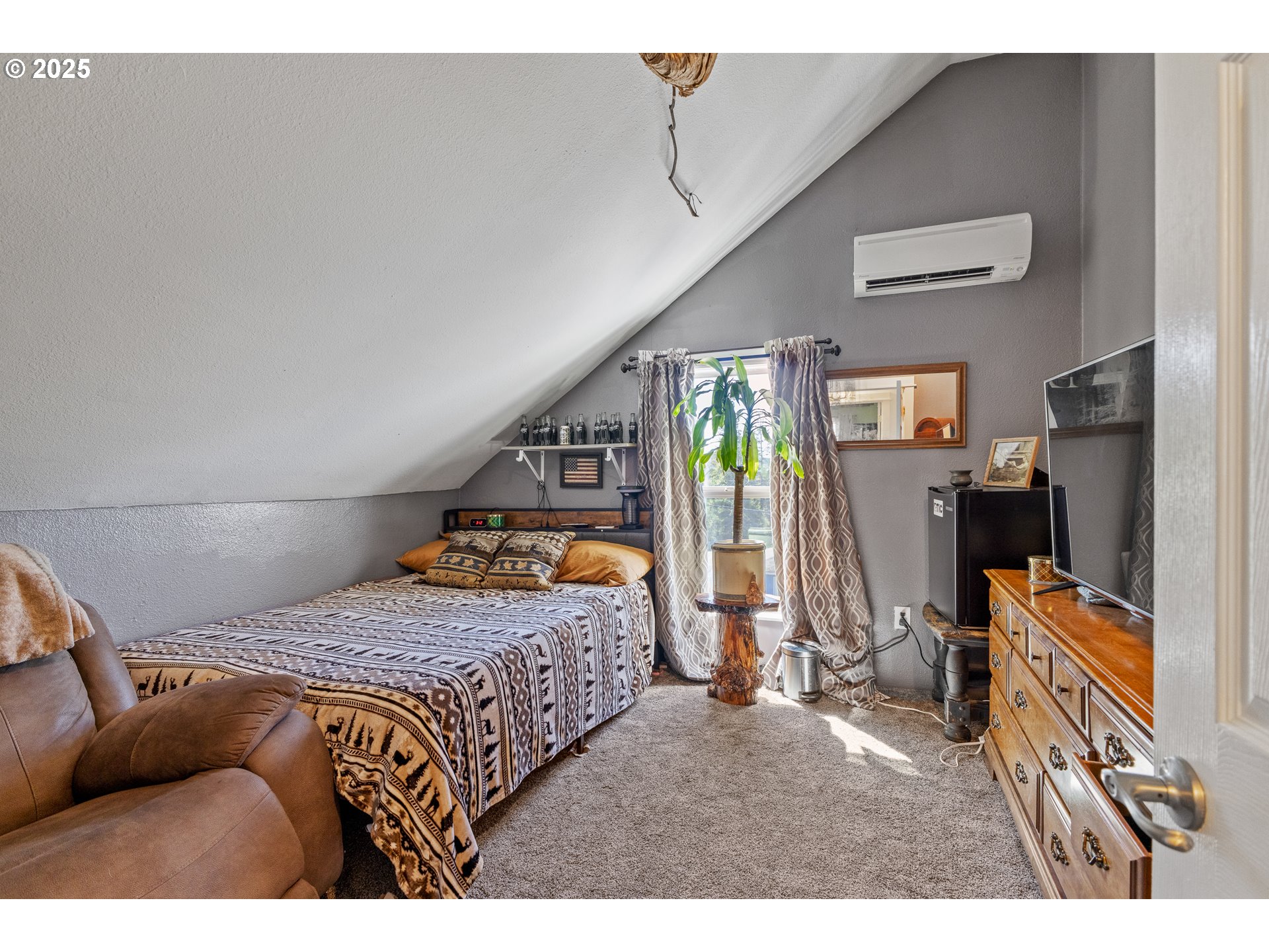 1753 20th Street Myrtle Point, OR 97458 - Photo 24 of 44 a bedroom with a bed a flat screen tv and a book shelf