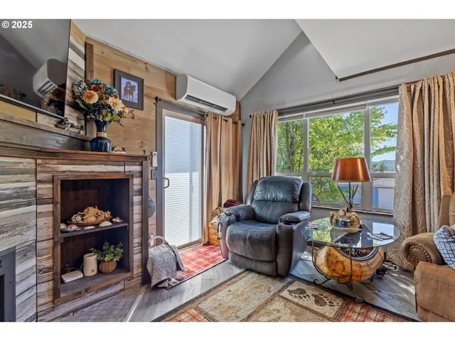 a living room with furniture a fireplace and a large window
