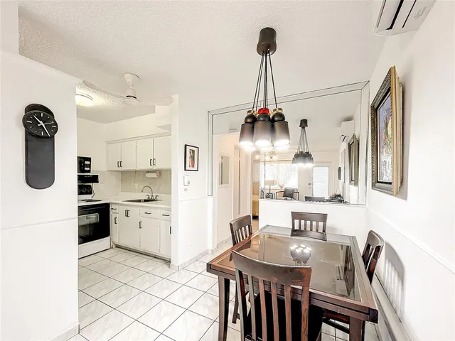 a kitchen with stainless steel appliances kitchen island granite countertop a dining table chairs and cabinets