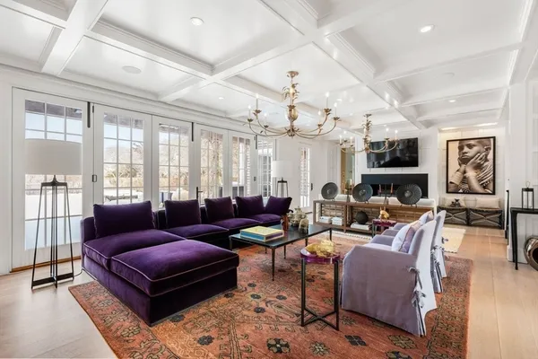 a living room with furniture kitchen view and a large window