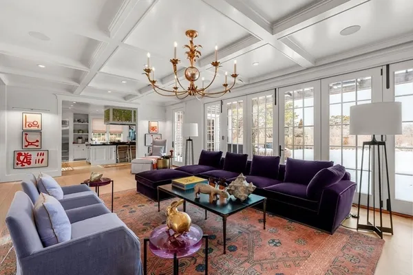 a living room with furniture kitchen view and a large window