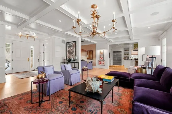 a living room with furniture a chandelier and a dining room