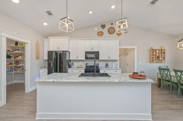 a kitchen with granite countertop counter space a sink appliances and cabinets
