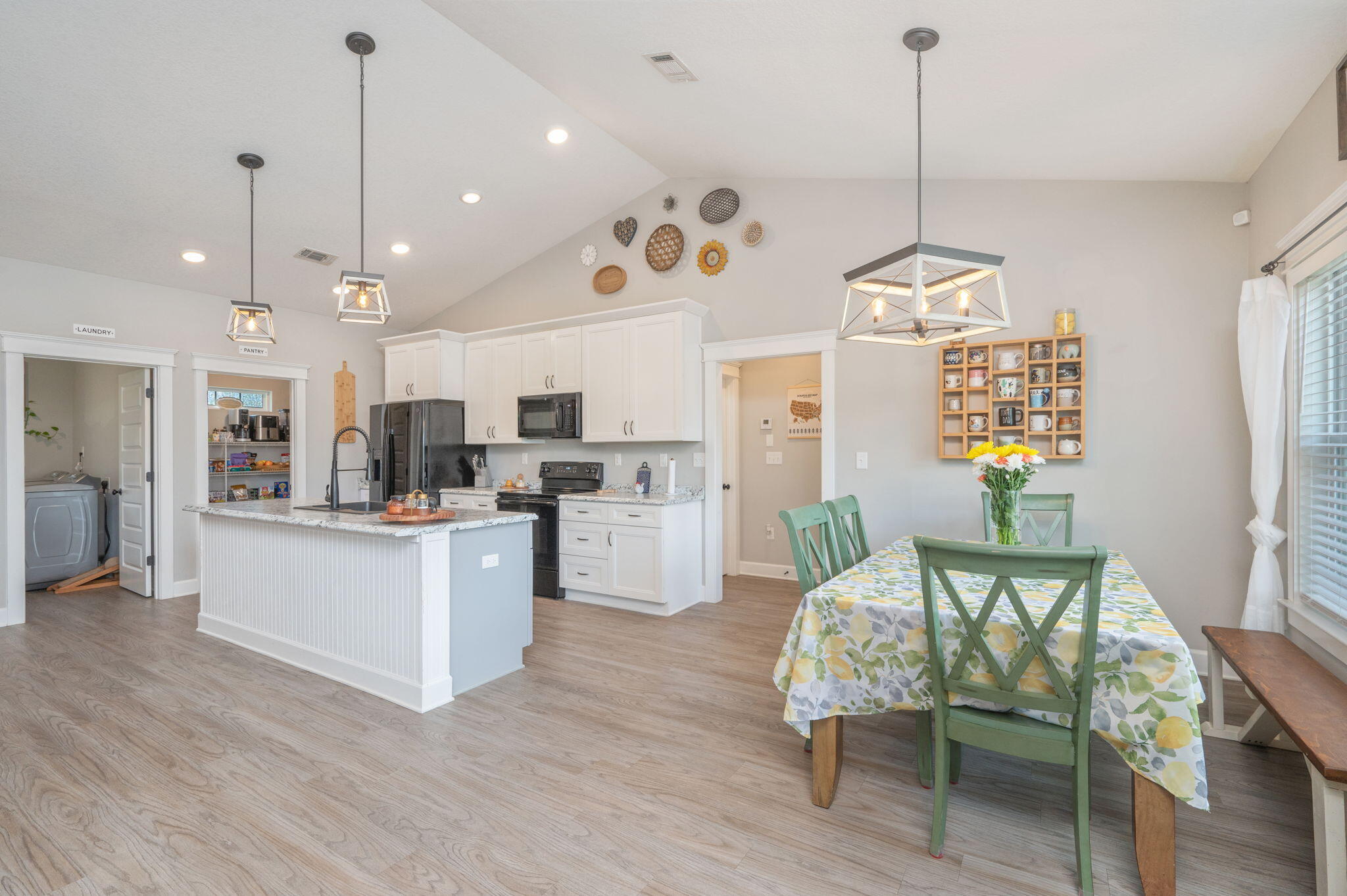 7934 Steel Mill Creek Road Laurel Hill, FL 32567 - Photo 24 of 63 a open kitchen with stainless steel appliances granite countertop a refrigerator a sink dishwasher a dining table and chairs with wooden floor