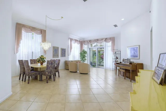 a living room with furniture a dining table and a potted plant
