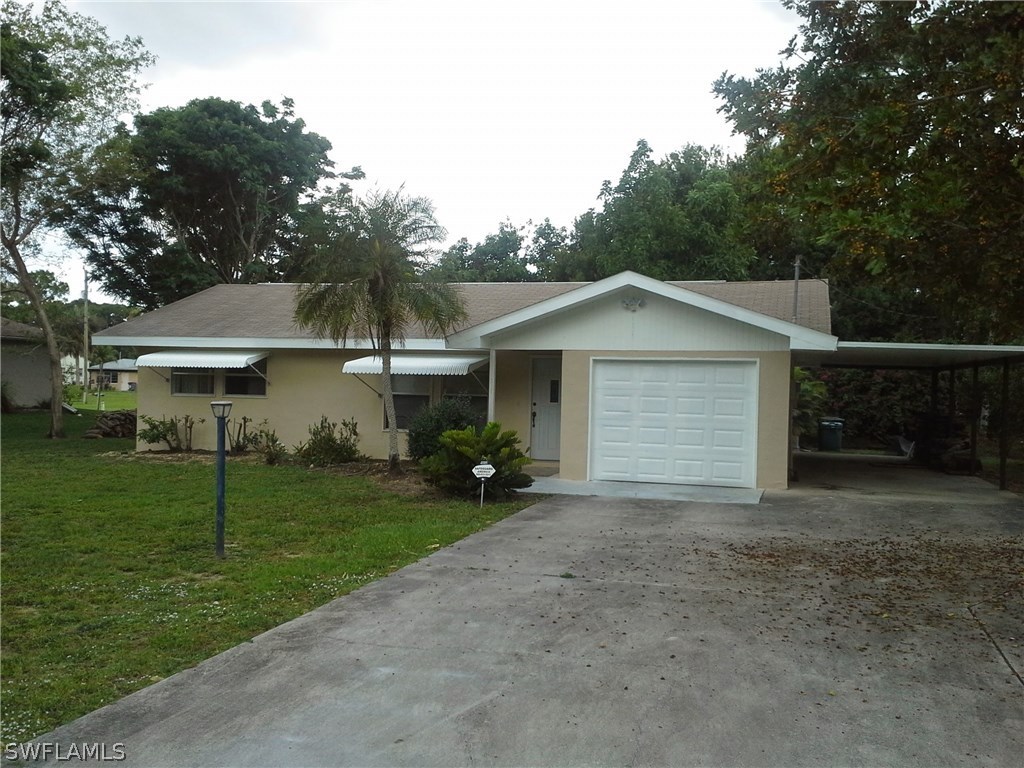 317 Maine Road Lehigh Acres, FL 33936 - Photo 1 of 5 a view of a house with yard and a garden