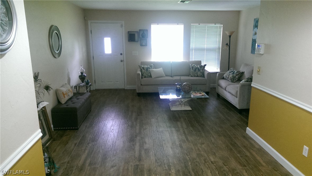 317 Maine Road Lehigh Acres, FL 33936 - Photo 4 of 5 a living room with furniture and a wooden floor