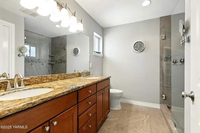a bathroom with a granite countertop sink toilet and shower