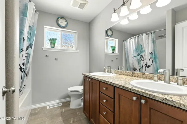 a bathroom with a granite countertop sink a toilet and a mirror