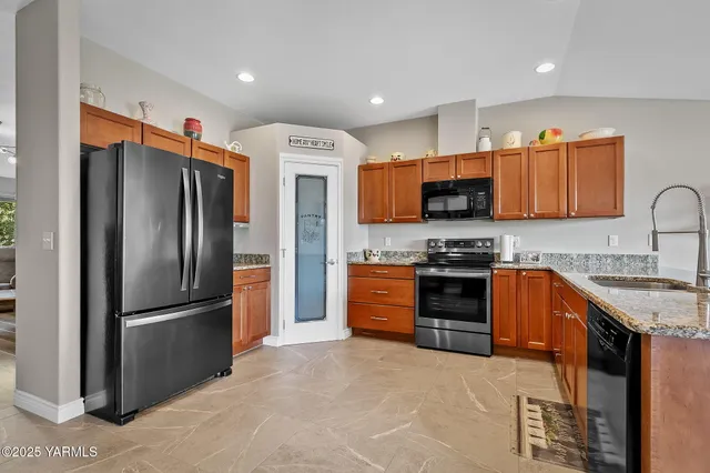 a kitchen with stainless steel appliances granite countertop a refrigerator stove and sink