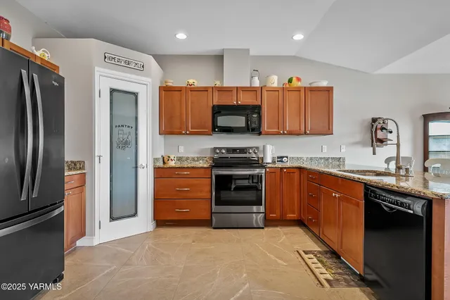 a kitchen with stainless steel appliances granite countertop a refrigerator and a stove top oven