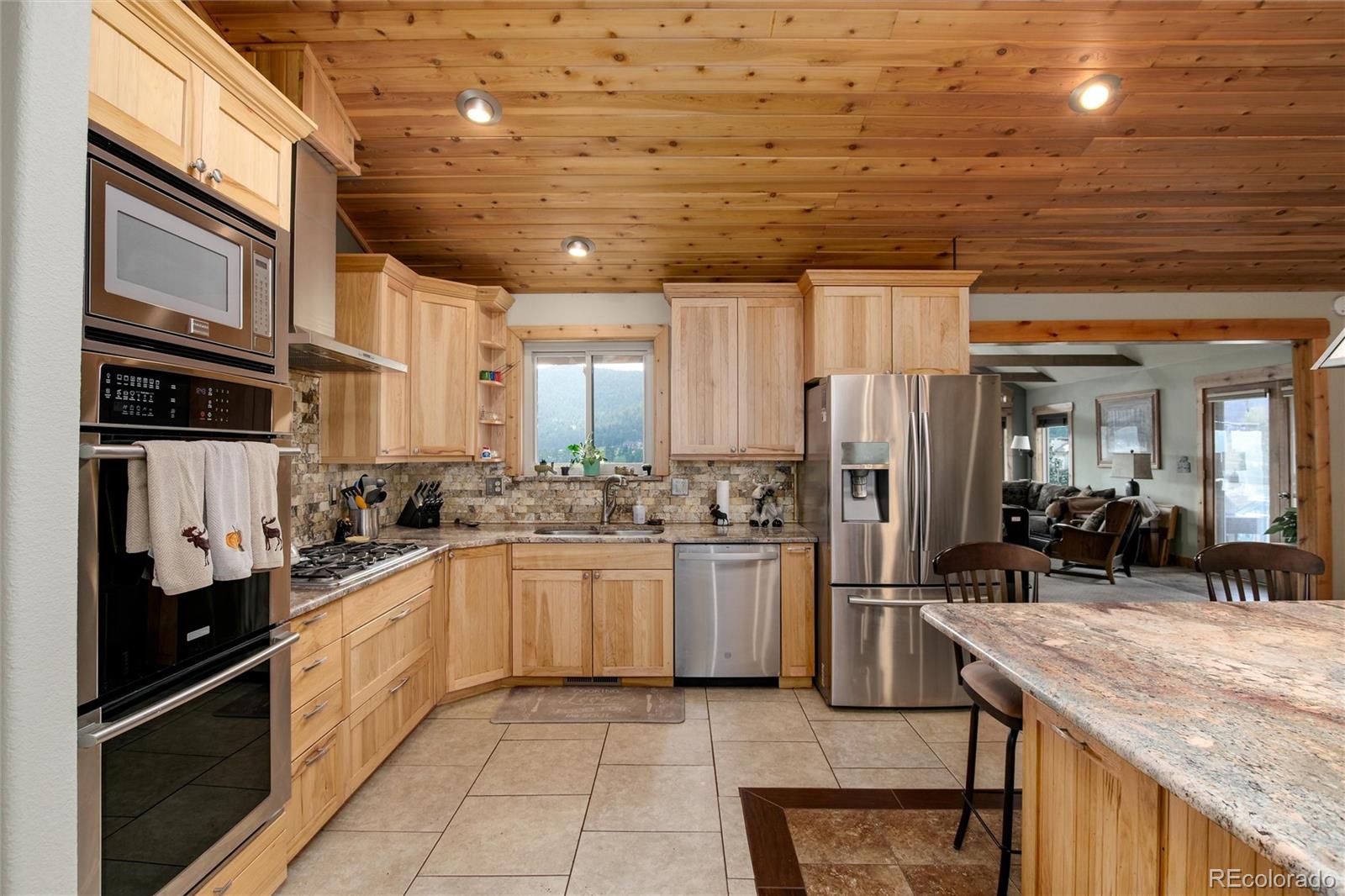 23724 Moqui Road Indian Hills, CO 80454 - Photo 13 of 39 a kitchen with stainless steel appliances granite countertop a sink stove and refrigerator