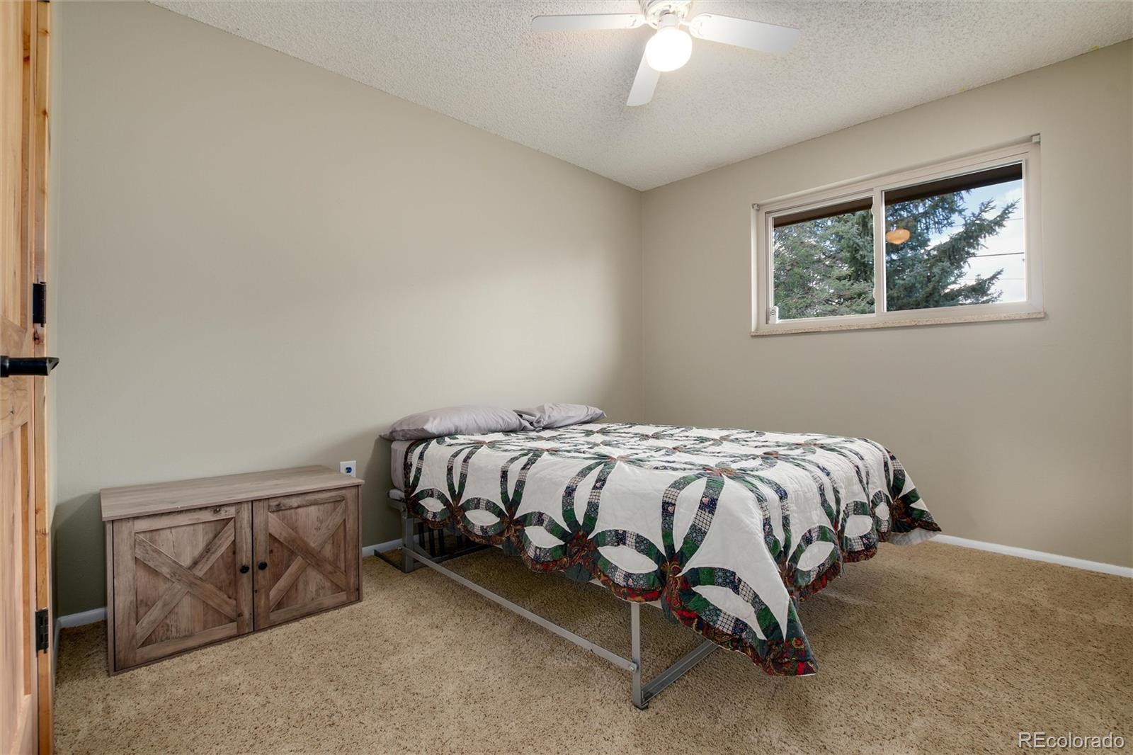 23724 Moqui Road Indian Hills, CO 80454 - Photo 22 of 39 a bed sitting in a bedroom next to a window