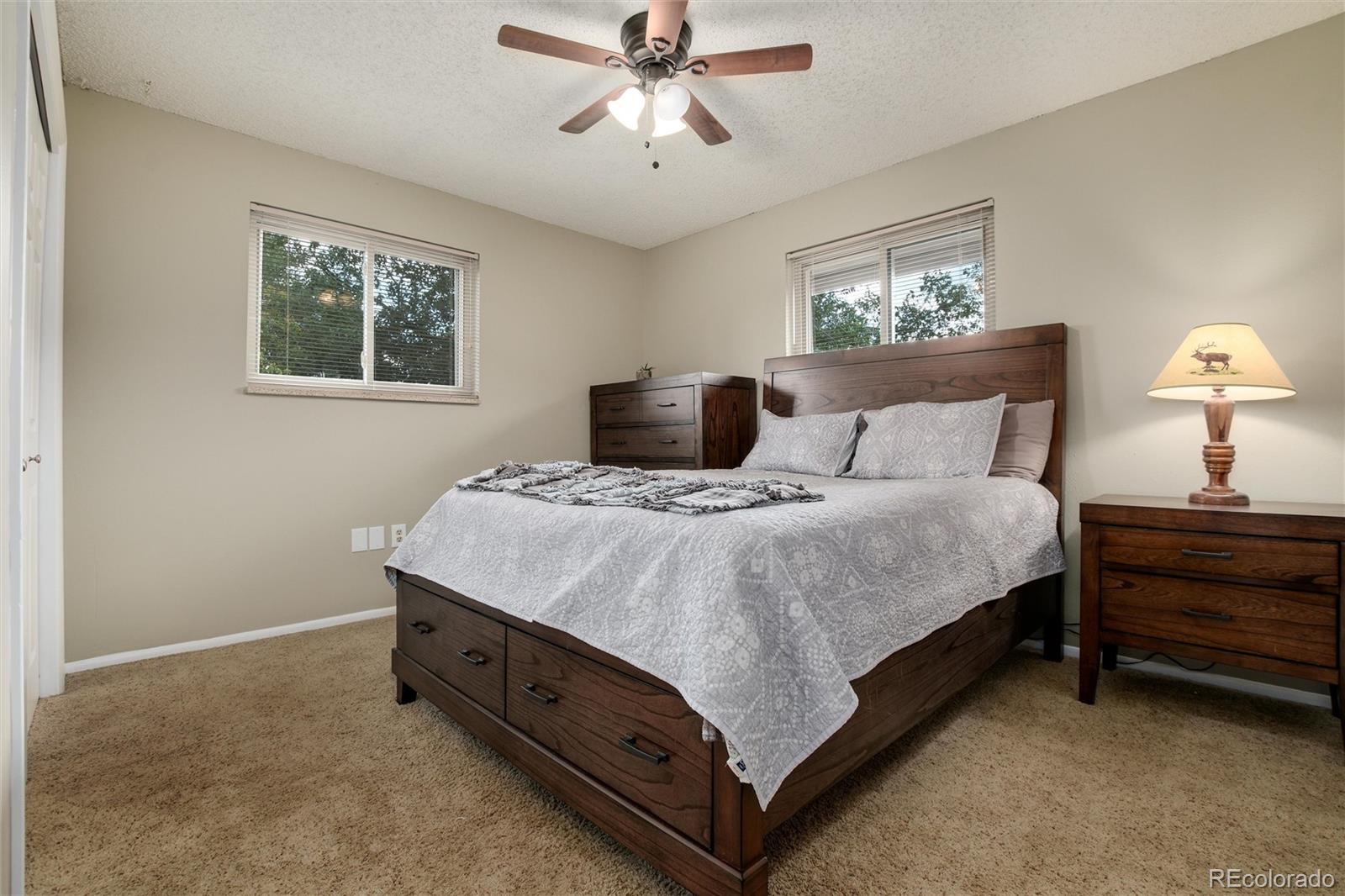 23724 Moqui Road Indian Hills, CO 80454 - Photo 24 of 39 a bedroom with a bed and a chandelier