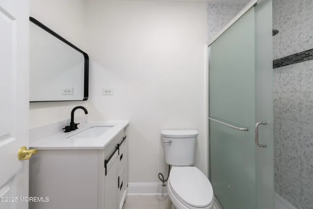 a bathroom with a toilet a sink and mirror
