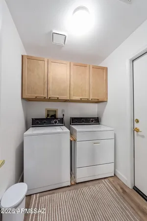 a view of washer and dryer with bathroom in the background