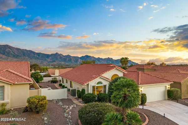 a front view of a house with a yard and mountain view