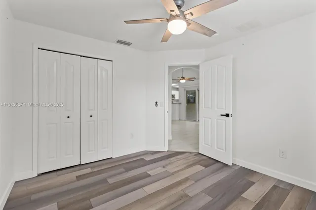 a view of empty room with window and ceiling fan
