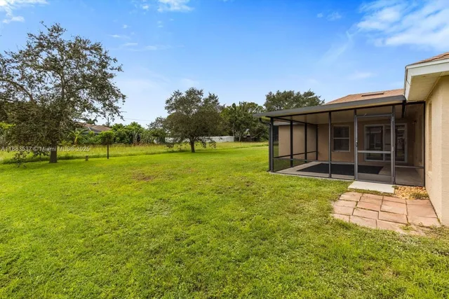a view of a green field with tree in the background
