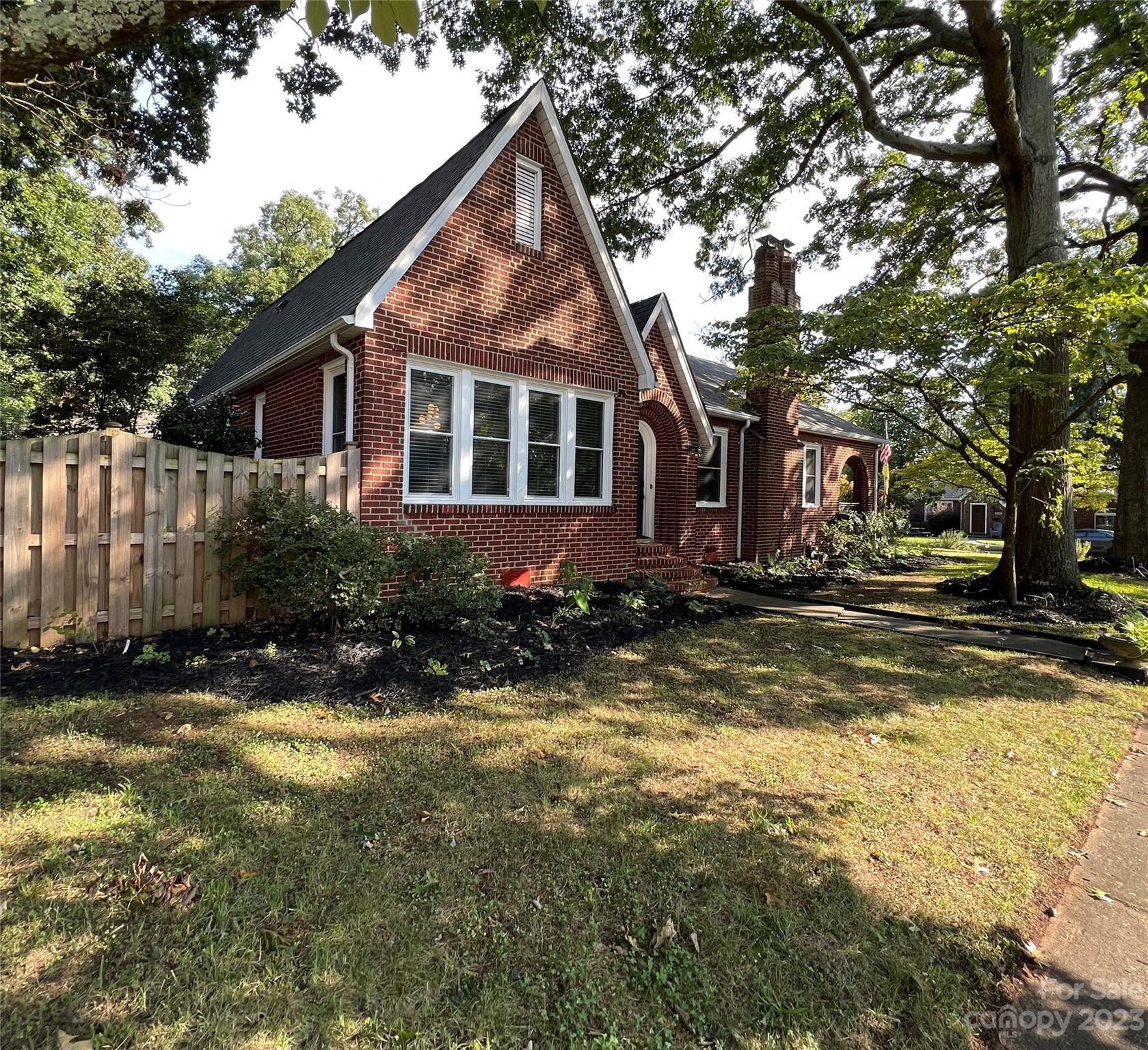 a front view of house with yard and trees around