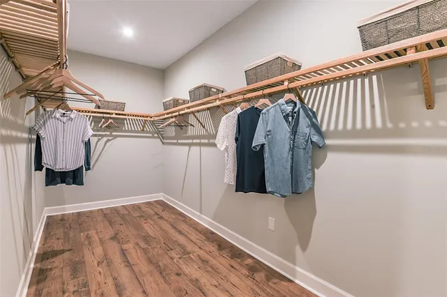 a spacious bedroom with a bed a couch and a chandelier