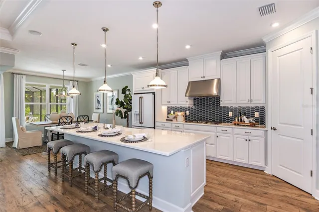 a dining room with furniture a chandelier and wooden floor