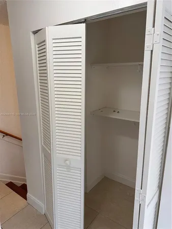 an empty room with a ceiling fan and glass door