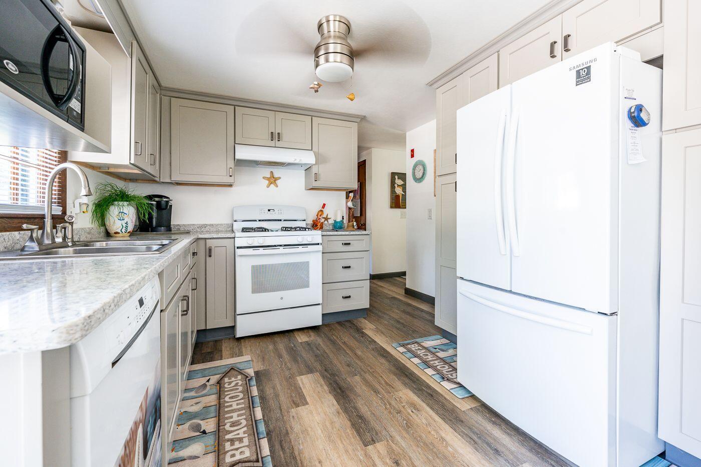 106 Old Great Neck Road Mashpee, MA 02649 - Photo 3 of 21 a kitchen with stainless steel appliances a refrigerator sink and cabinets