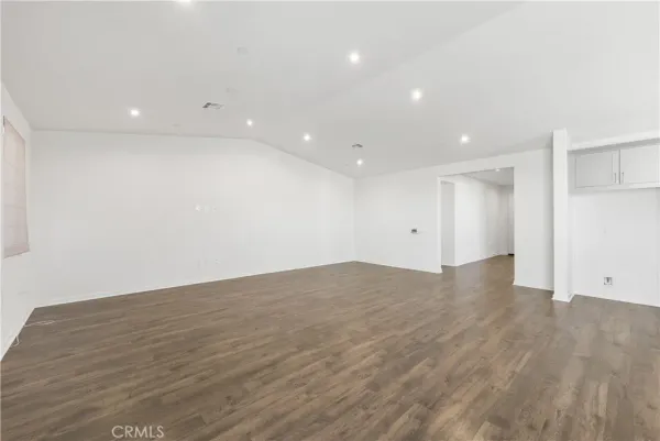 a view of an empty room with wooden floor