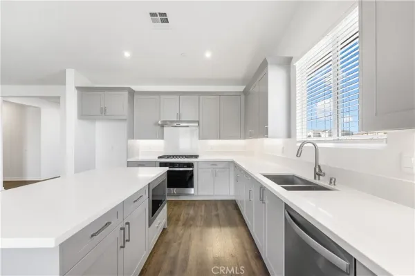a view of a kitchen with a sink and wooden floor