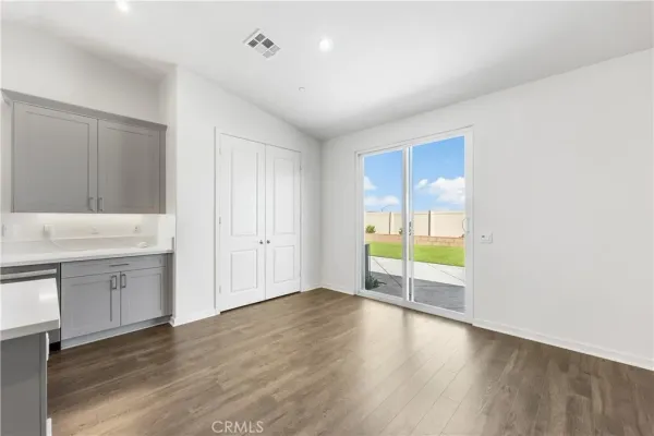 a view of an empty room with window and wooden floor