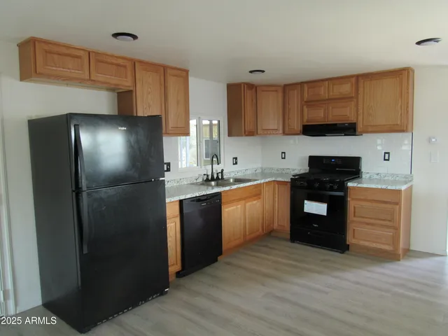 a kitchen with a refrigerator sink and cabinets