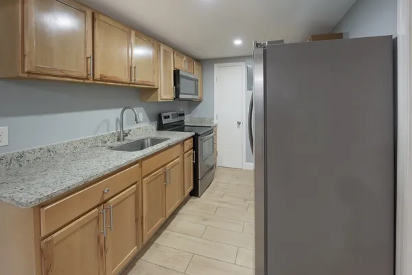 a kitchen with stainless steel appliances granite countertop a sink and cabinets