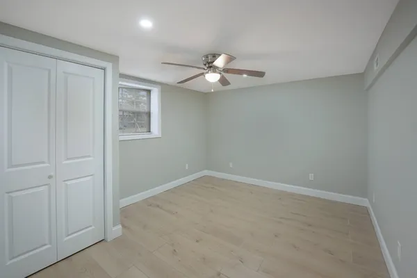 an empty room with closet and a ceiling fan