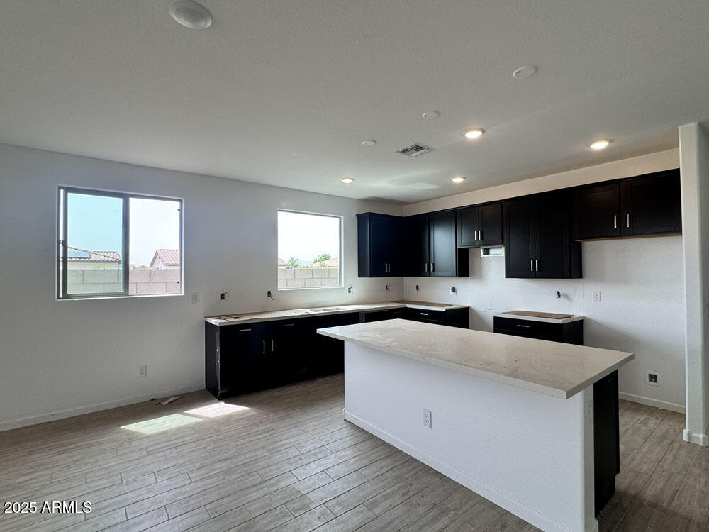 15793 West Beryl Avenue Waddell, AZ 85355 - Photo 8 of 34 a large kitchen with stainless steel appliances a large counter top a stove a sink a refrigerator and a microwave