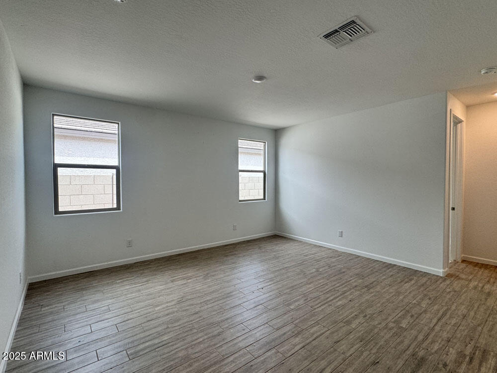 15793 West Beryl Avenue Waddell, AZ 85355 - Photo 10 of 34 an empty room with wooden floor and windows