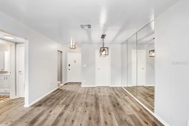 a view of a hallway with wooden floor and a ceiling fan