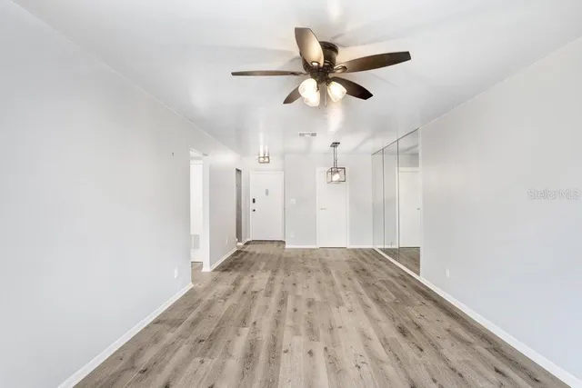 a view of empty room with wooden floor